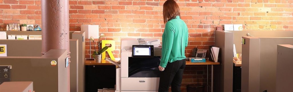 woman in green using printer