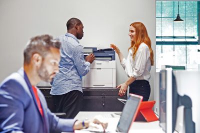 Coworkers working together at their managed print services printer