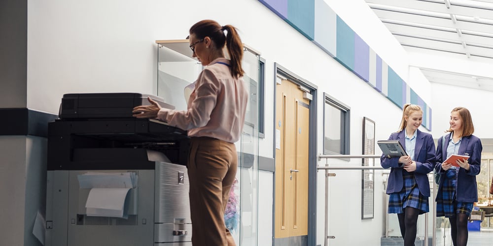 woman printing in school hallway